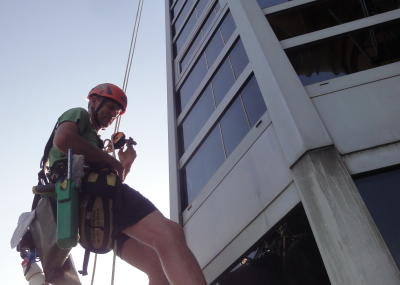 Industriekletterer bei Glasreinigung am hängenden Seil, Arbeit am Seil in der Höhe