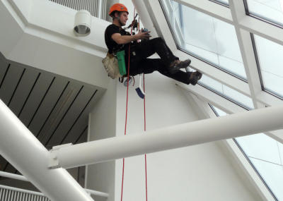 Industriekletterer bei Glasreinigung am hängenden Seil, Arbeit am Seil