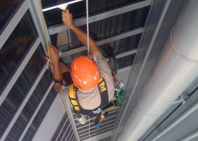 Industriekletterer bei Glasreinigung am hängenden Seil, Arbeit in der Höhe ohne Gerüst